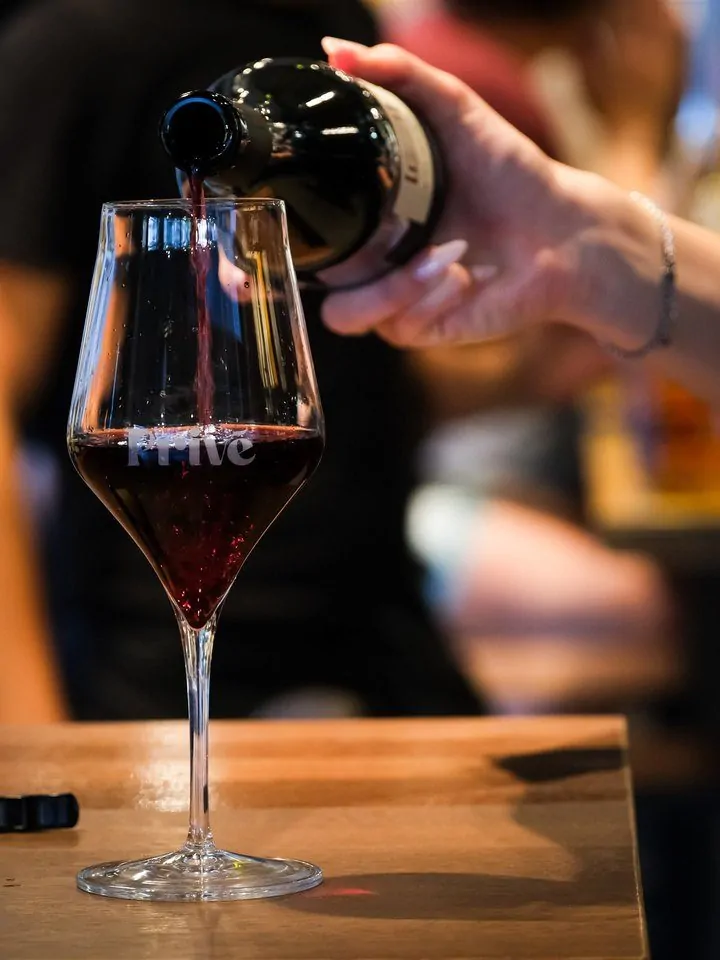 Vino rosso versato nel calice al Privè